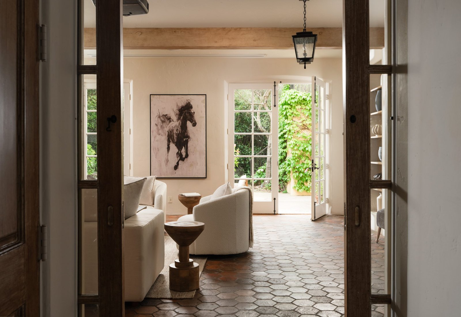 Living room with arched doors opening to a garden view, staged by S & S Interiors
