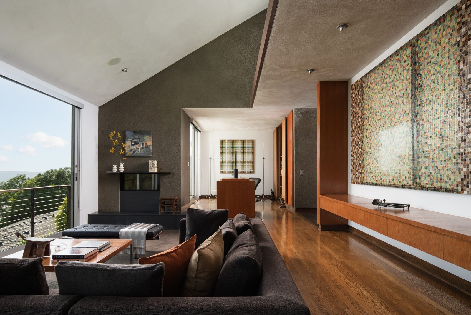Dark, moody living room staged with floor-to-ceiling windows